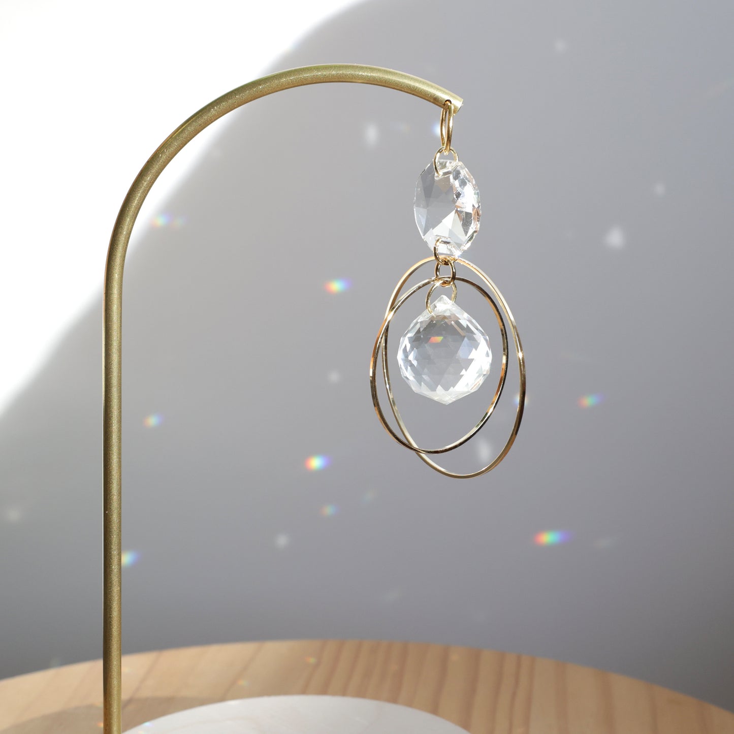 Suncatcher DAYDREAM capturant la lumière pour créer des reflets arcs-en-ciel dans la pièce. Fabriqué par Rayonne