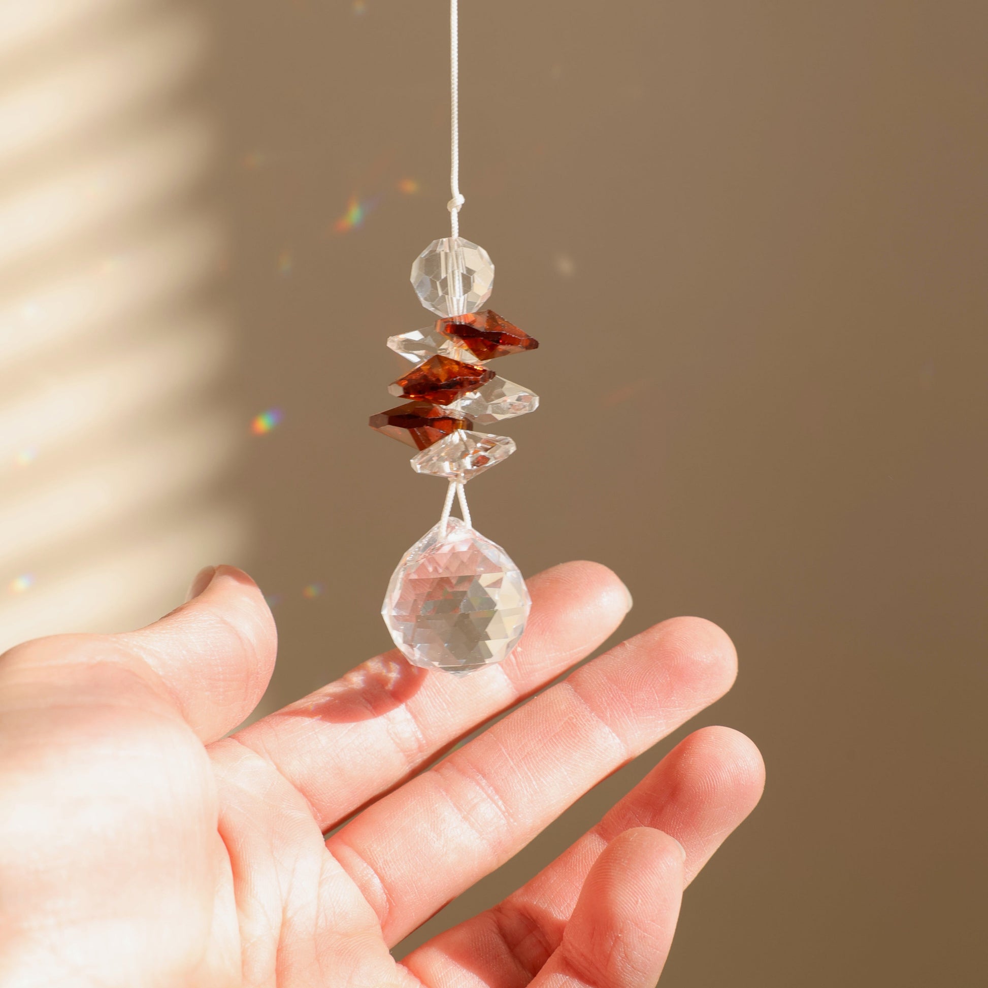 suncatcher en cristal qui projette des prismes lumineux 