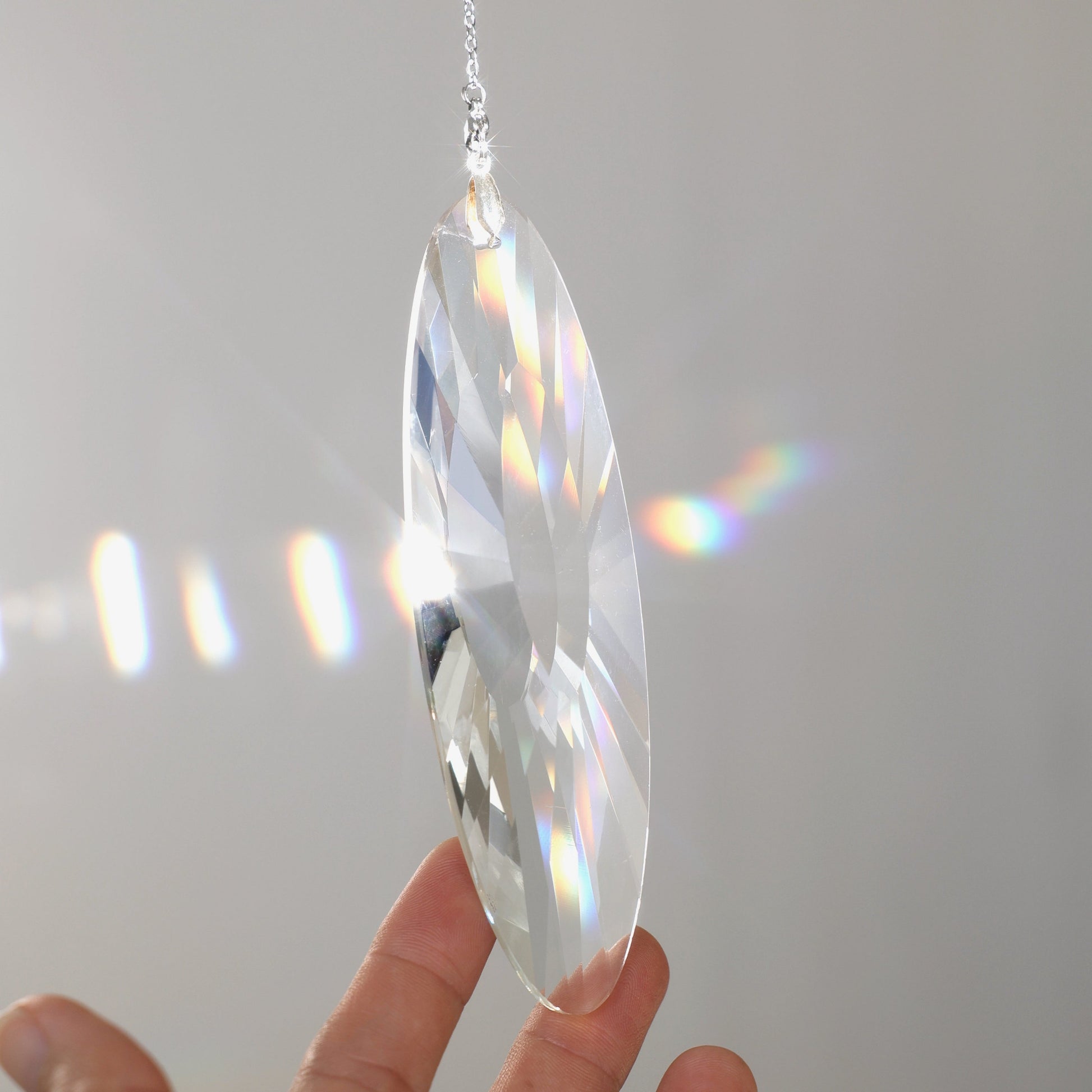 suncatcher en cristal de verre tenu par une main 