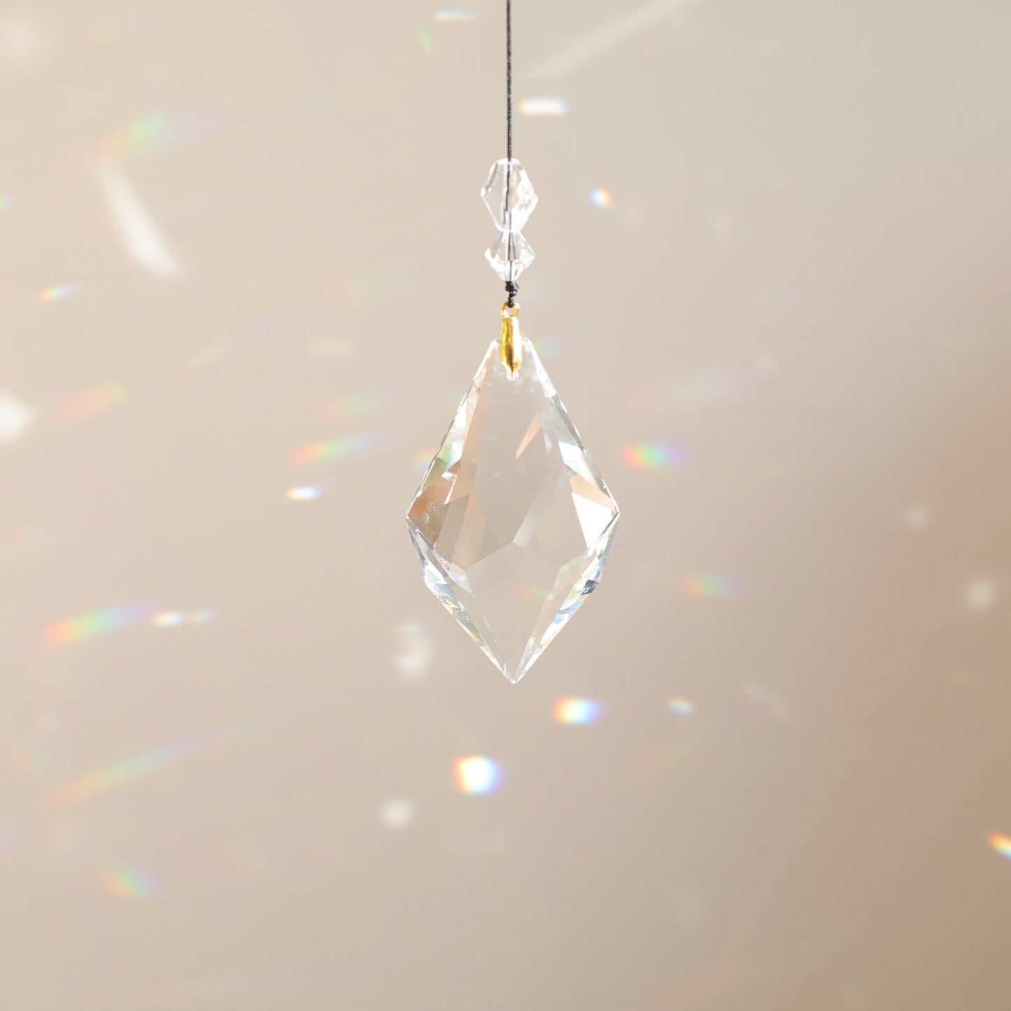 suncatcher en cristal suspendu sur un fond beige