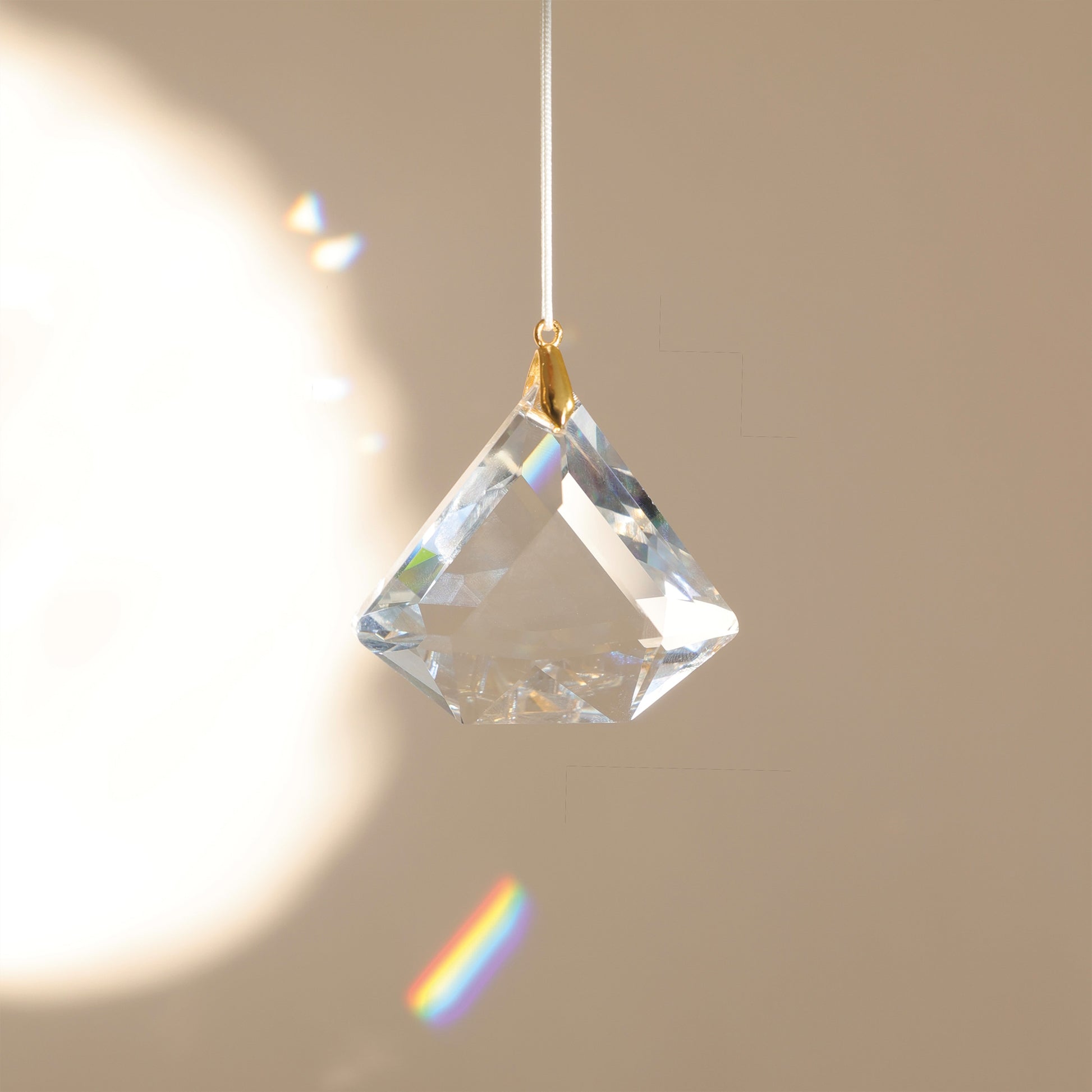 Suncatcher ASTRA en cristal, diffusant des reflets arc-en-ciel dans une pièce lumineuse pour créer une ambiance douce et harmonieuse