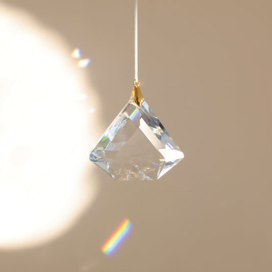 Suncatcher ASTRA en cristal, diffusant des reflets arc-en-ciel dans une pièce lumineuse pour créer une ambiance douce et harmonieuse