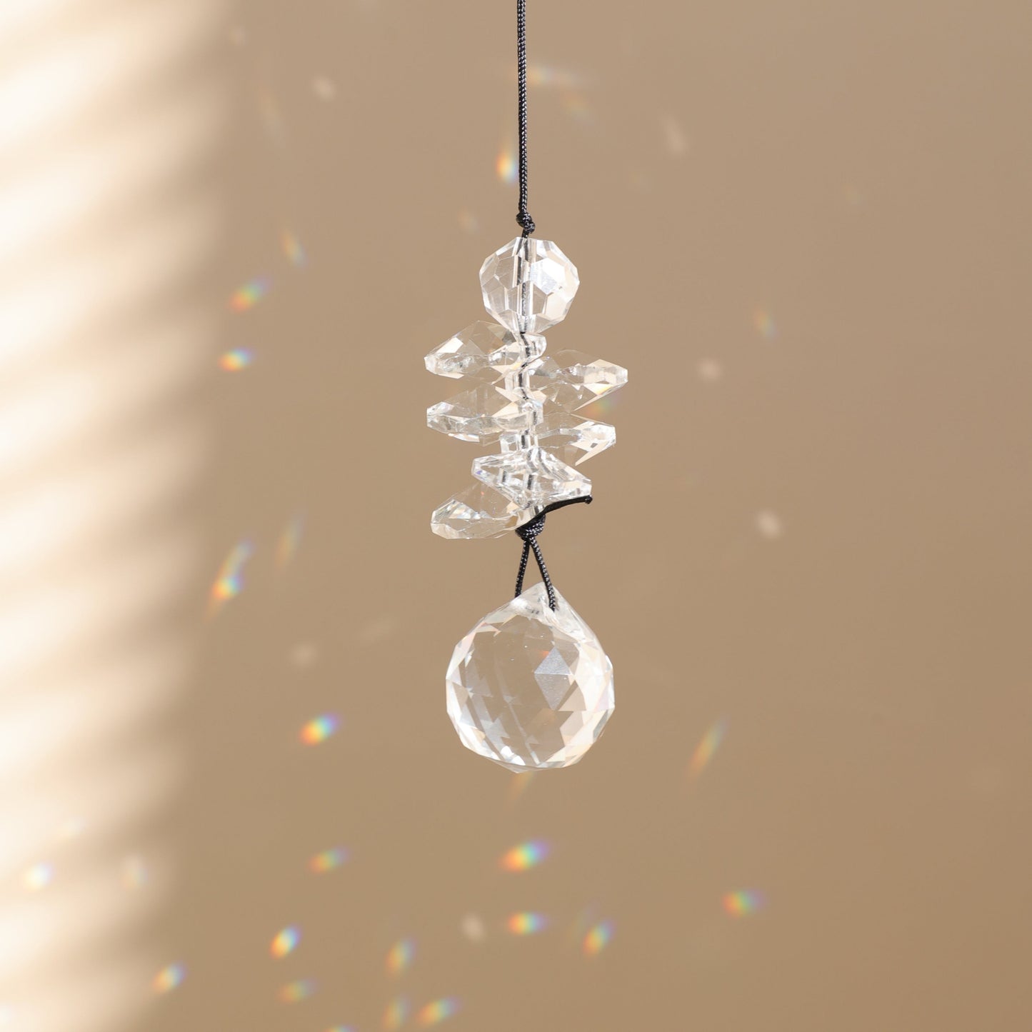 petit suncatcher en cristal suspendu et diffusant des prismes arc-en-ciel 