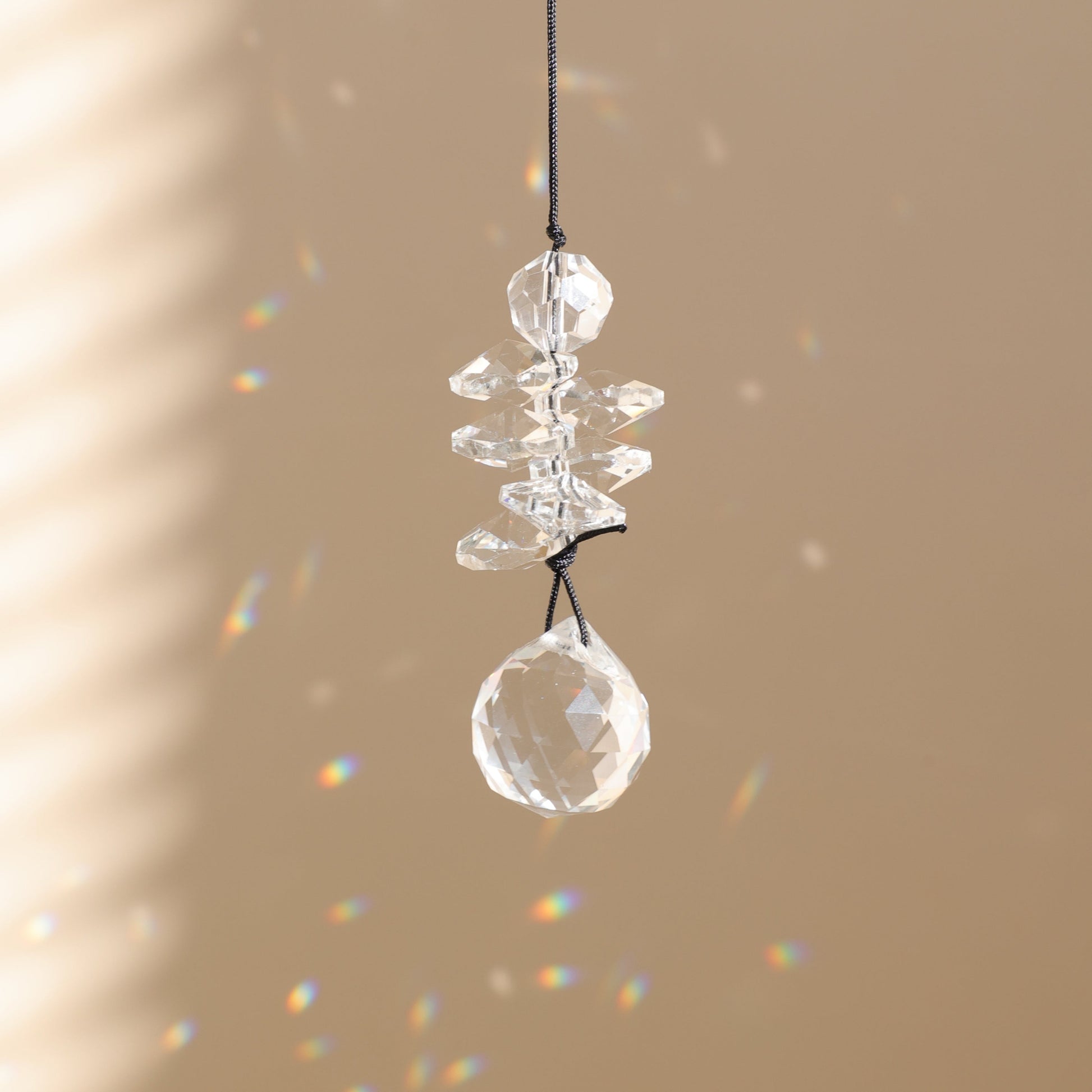 petit suncatcher en cristal suspendu et diffusant des prismes arc-en-ciel 