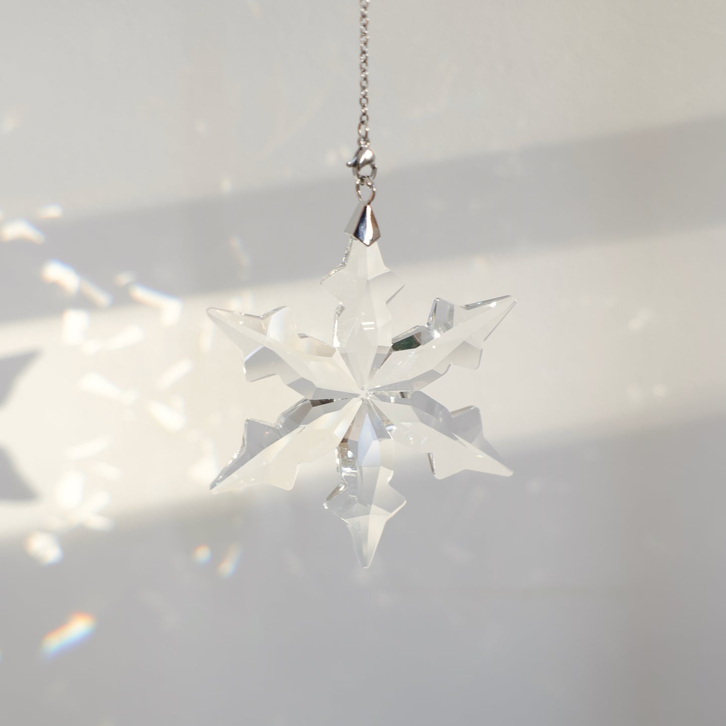 flocon en cristal projettant des prismes sur un mur