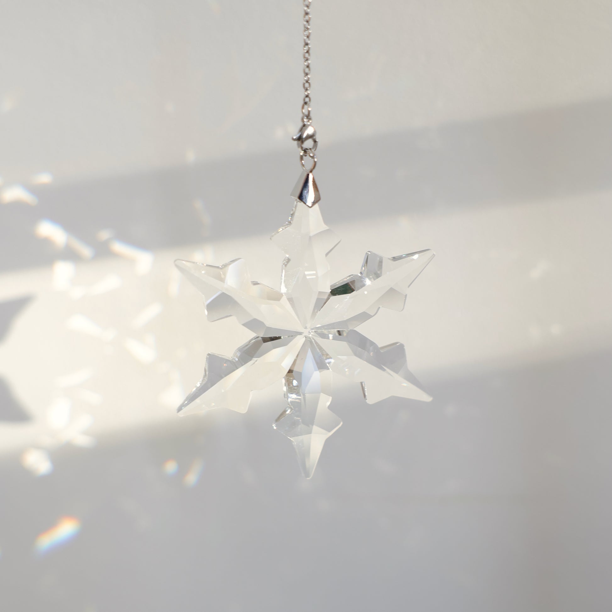 flocon en cristal projettant des prismes sur un mur