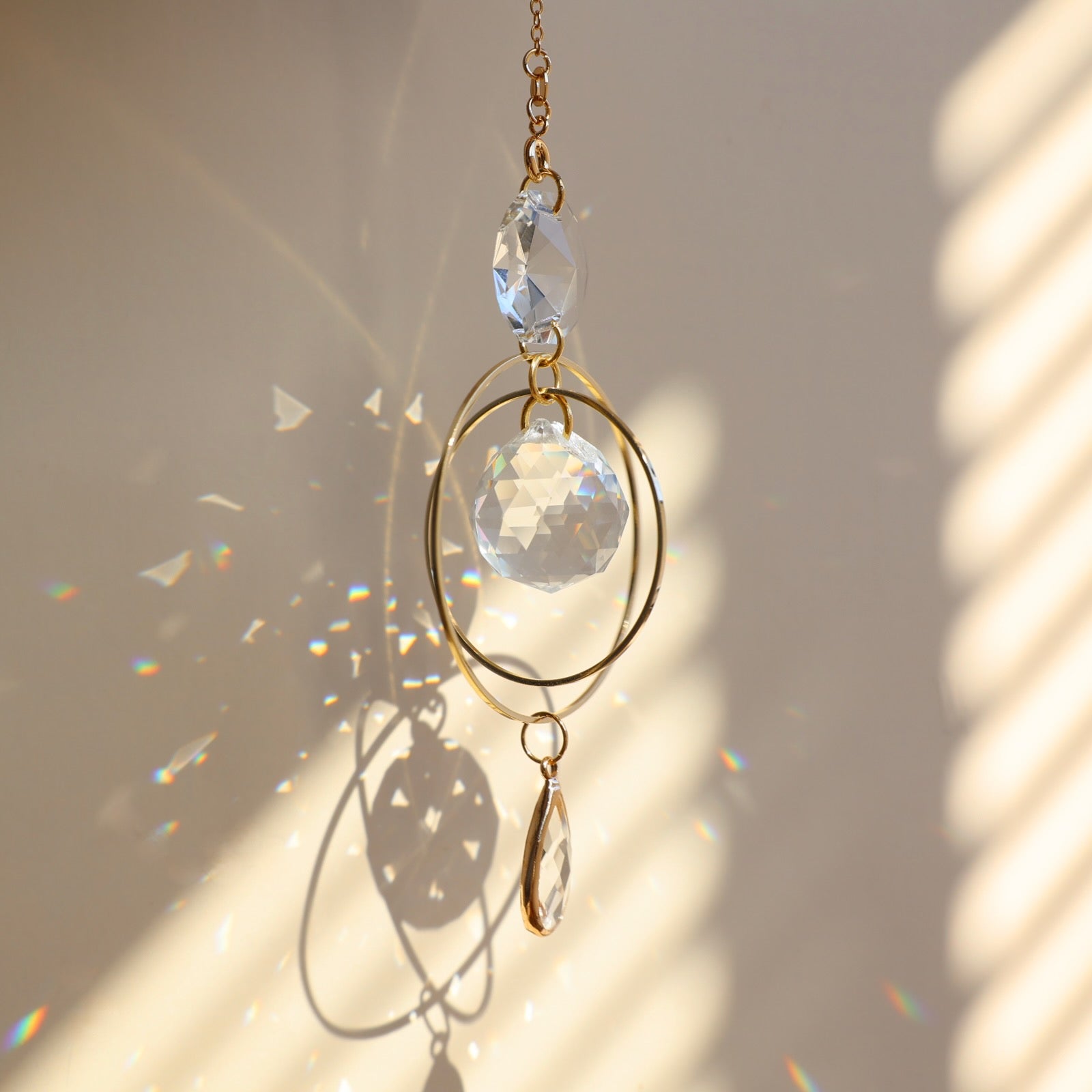 suncatcher suspendu qui reflète des prismes arcs-en-ciel