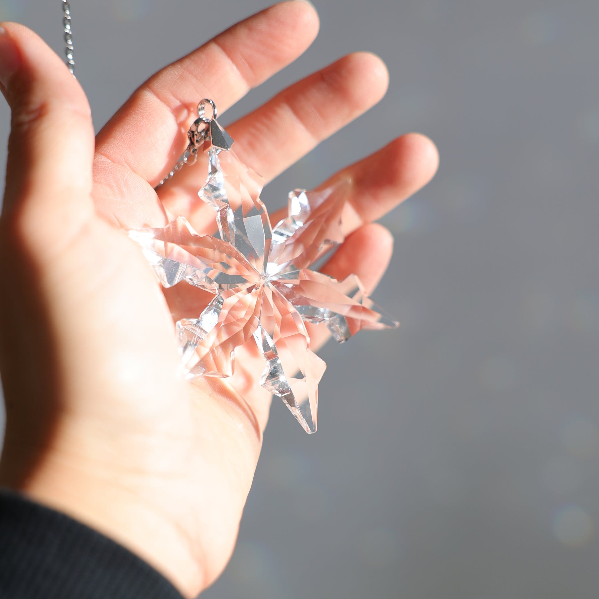 flocon en cristal tenu dans une main 