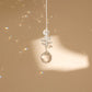 suncatcher en cristal suspendu sur un fond beige 