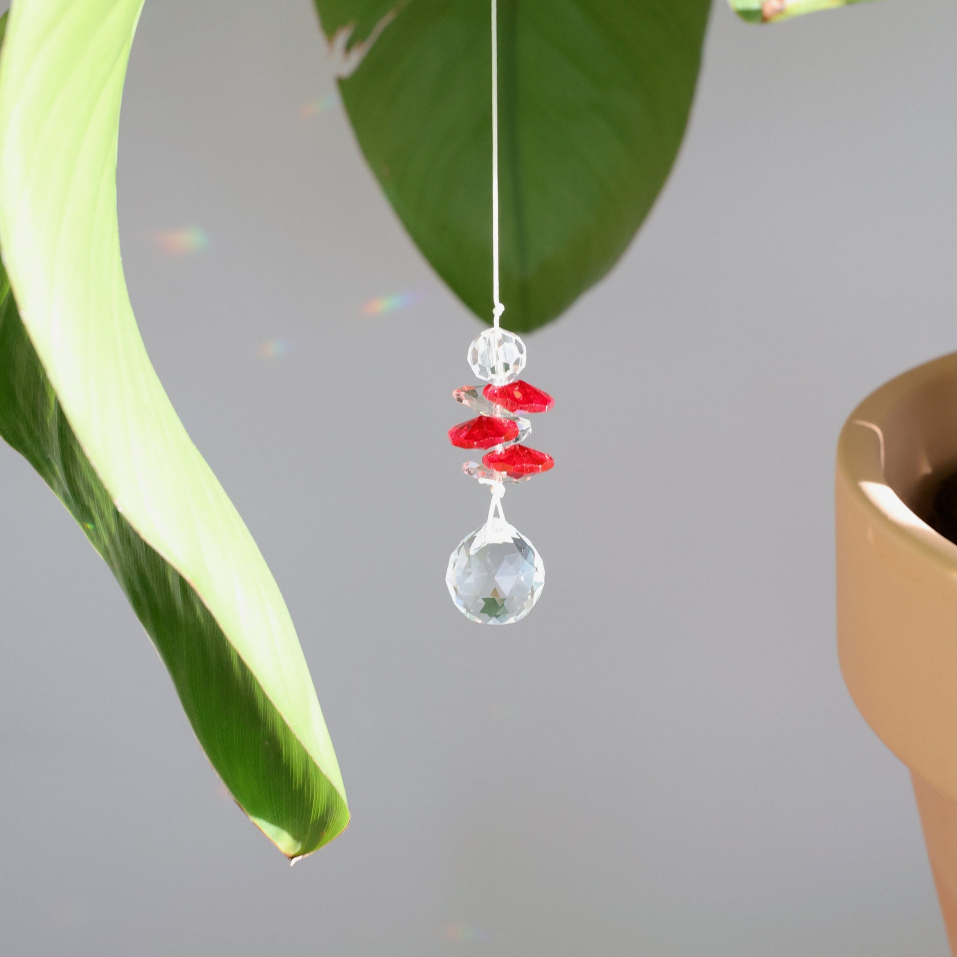 suncatcher en cristal rouge suspendu à une plante