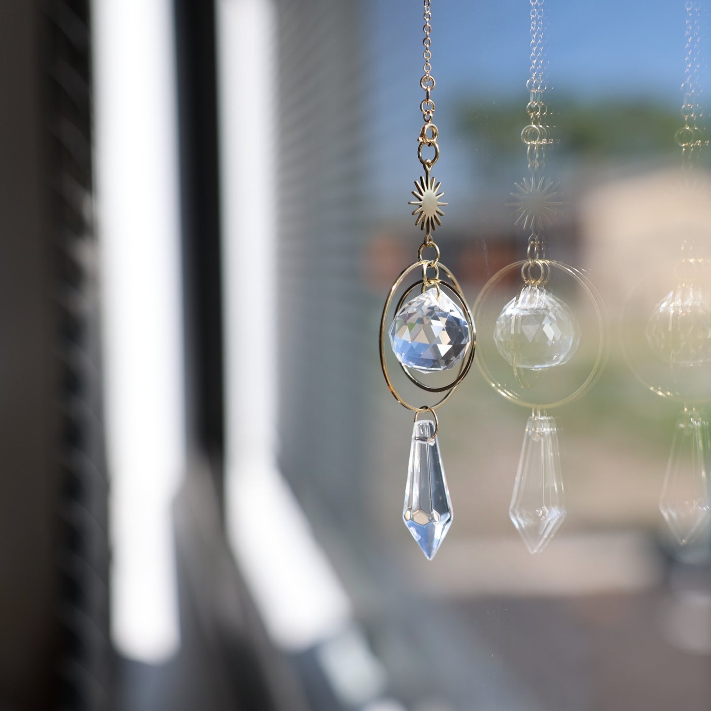 suncatcher rayonne suspendu à une fenetre 